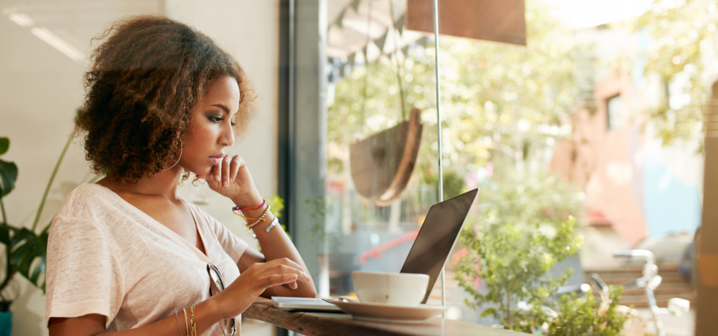 Black woman reading on laptop